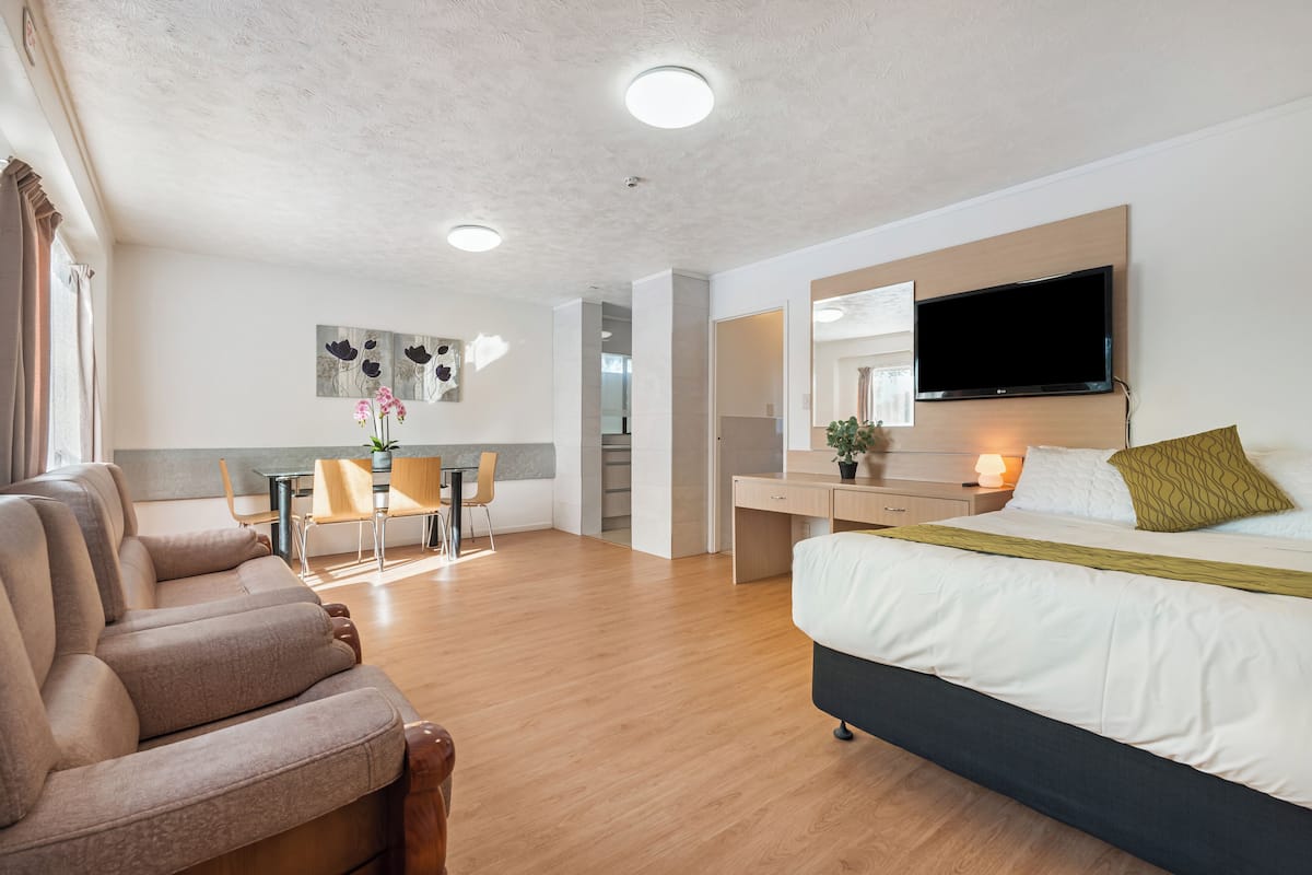 Une chambre d’hôtel moderne équipée d’un canapé, d’un lit, d’un bureau et d’une télévision.
