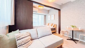 Une chambre d’hôtel moderne avec un canapé, une petite table et une vue sur la ville.