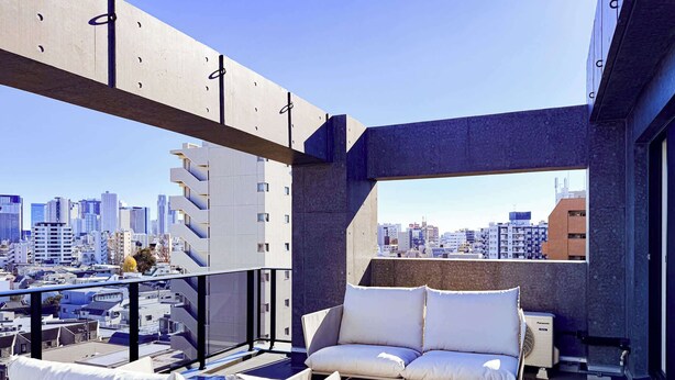 A balcony with a city view, a sofa, and a fan. - Triphome Nakano 2025 New 6min JR 4min Shinjuku (Nakano City)