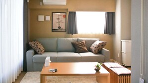 A modern living room with a grey sofa, a wooden coffee table, and a radiator. - Triphome Nakano 2025 New 6min JR 4min Shinjuku (Nakano City)