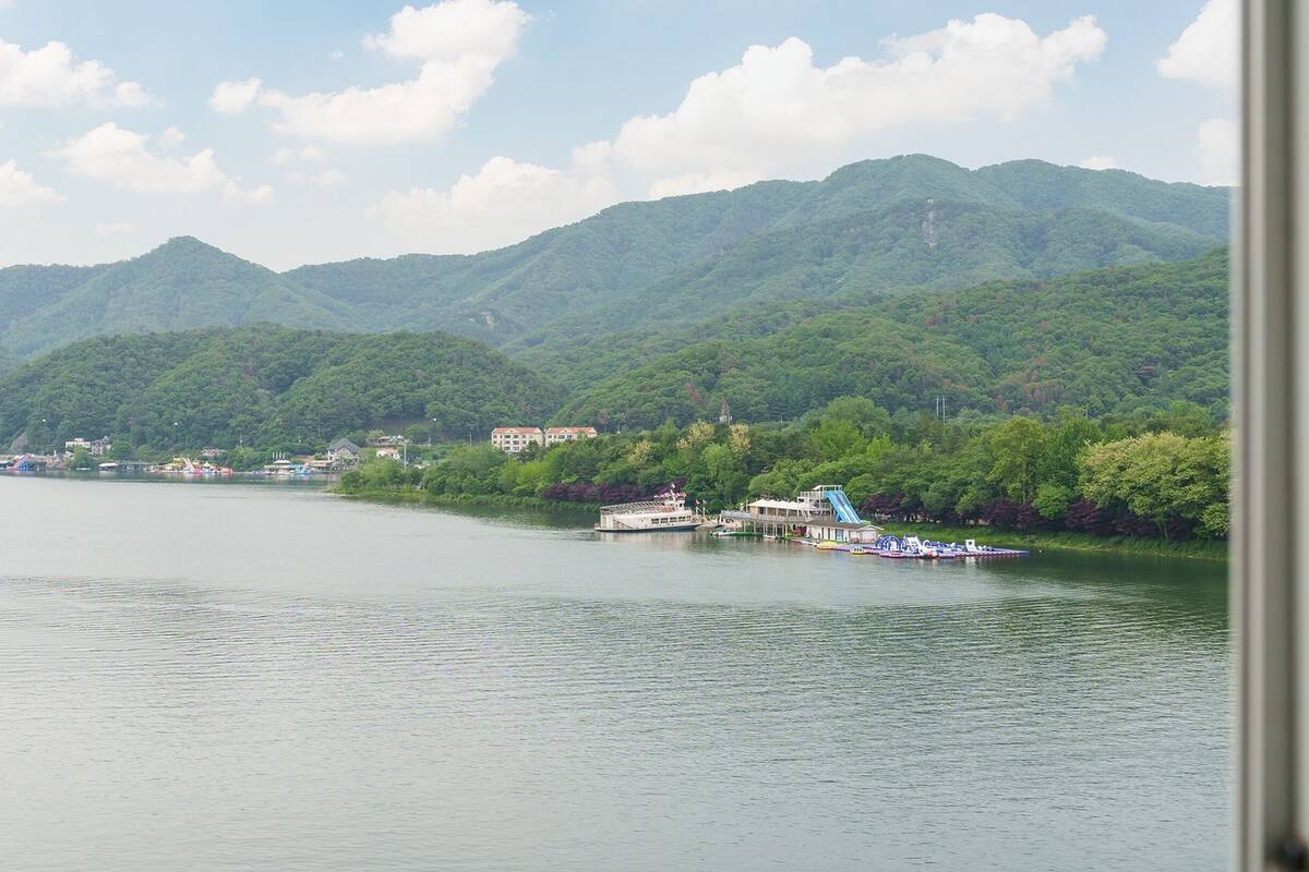 A river with boats, a dock, and buildings along the shore.