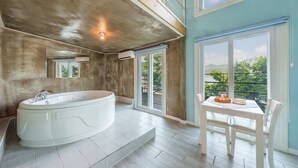 A spacious bathroom with a freestanding bathtub, a large mirror, and a sliding glass door leading to an outdoor area. - Gapyeong Nami Island Pool & Spa Pension (Gapyeong)