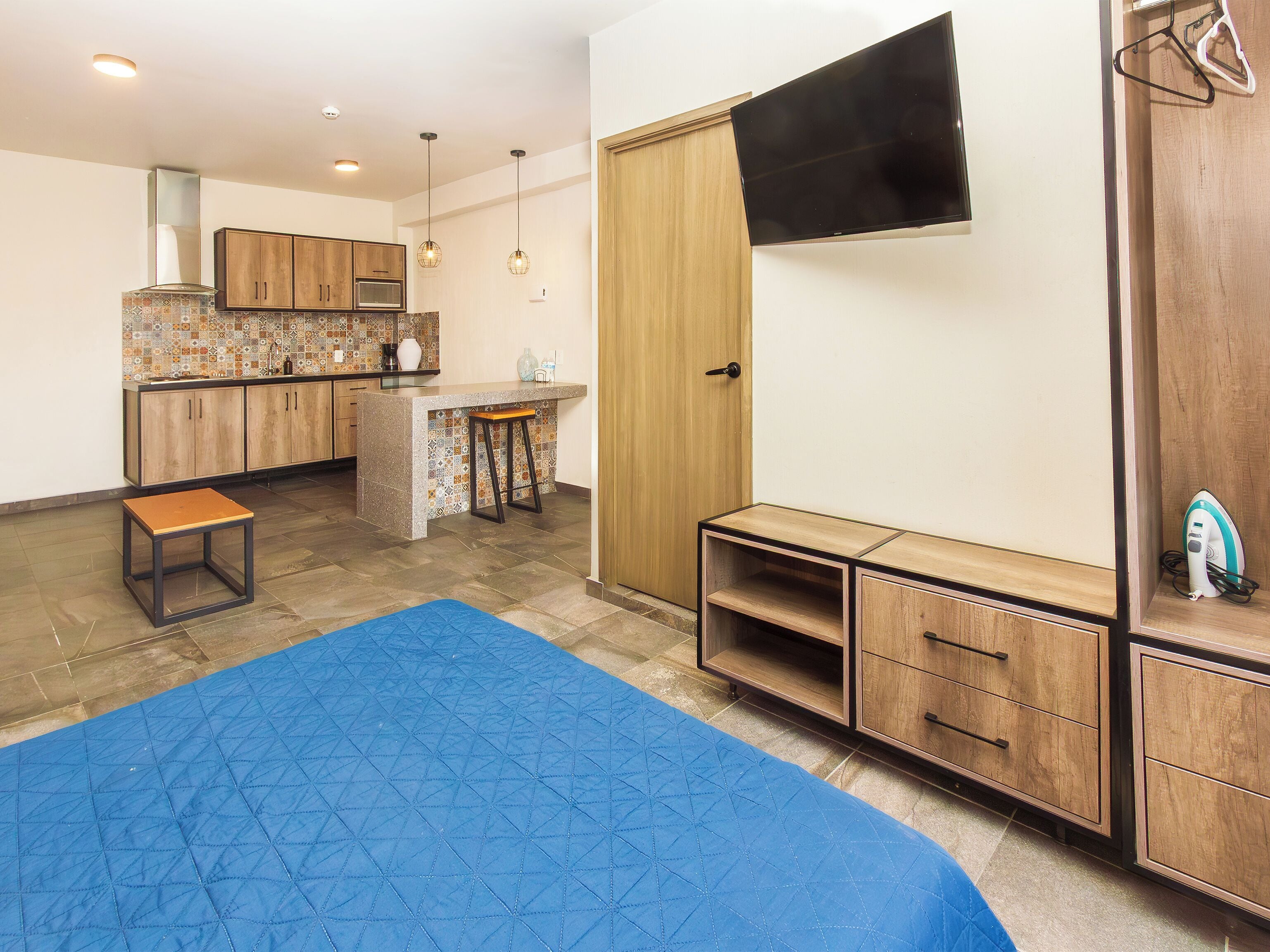 A compact kitchen with wooden cabinets, a countertop, and a built-in oven.
