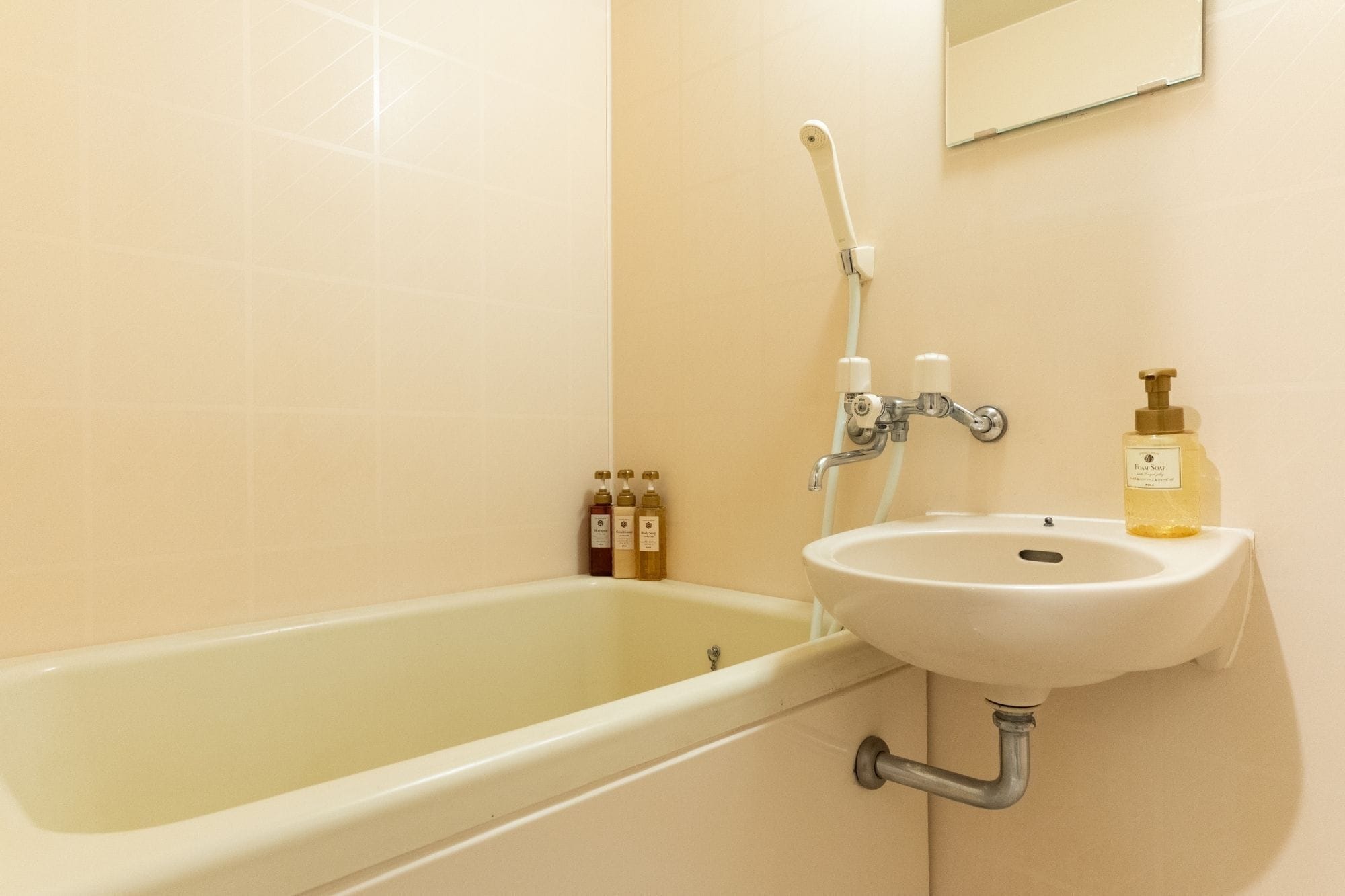 A bathroom with a bathtub, a sink, and toiletries.