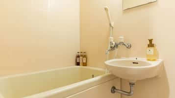 A bathroom with a bathtub, a sink, and toiletries.