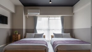 Ein modernes Schlafzimmer mit zwei Betten, einem Deckenventilator und einem großen Fenster mit Vorhängen.