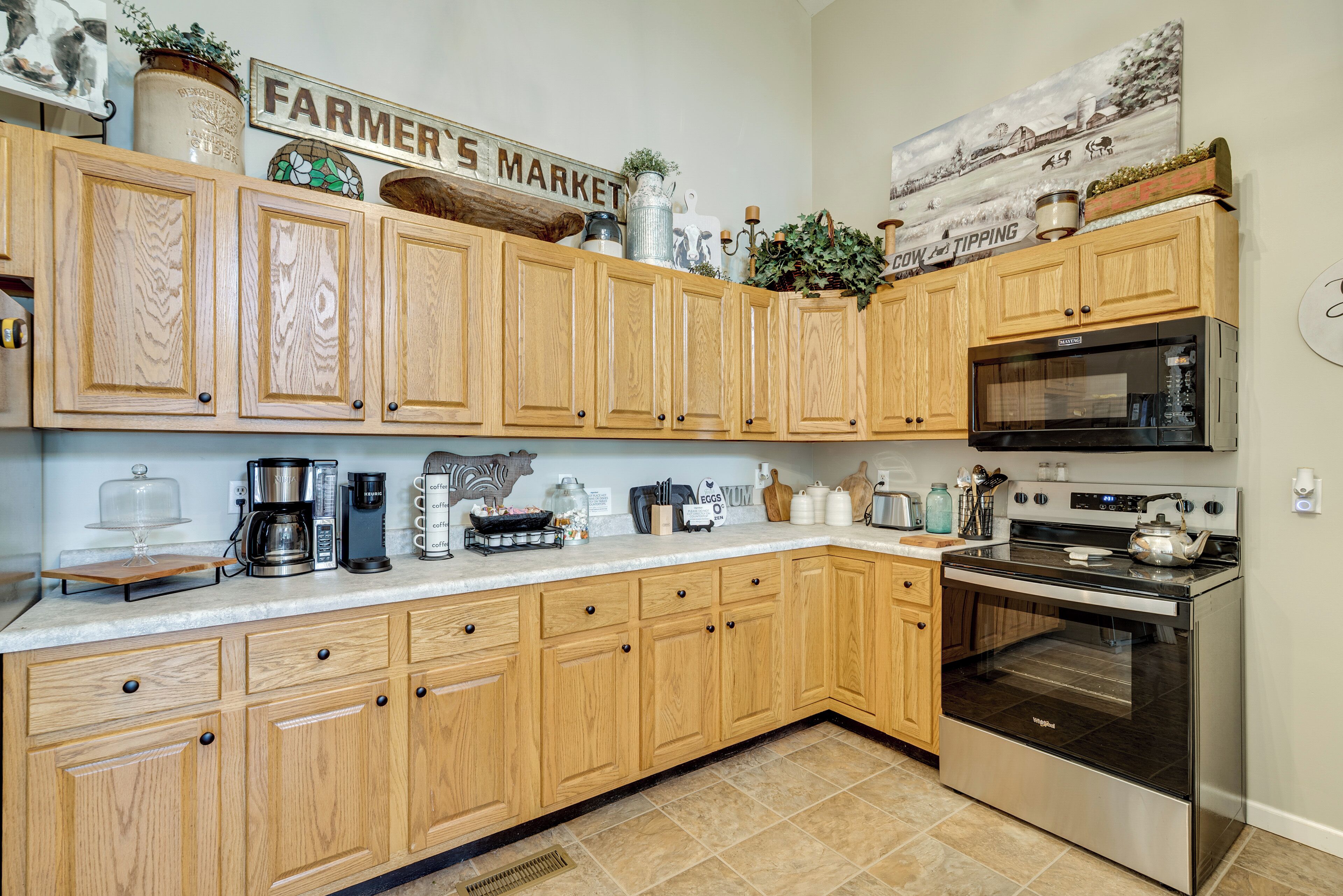 A kitchen with wooden cabinets, a stove, and various kitchen appliances.