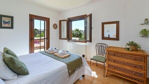 A bedroom with a bed, a chair, a dresser, and two windows. - Ines Isabel - Javea, Costa Blanca (Javea)