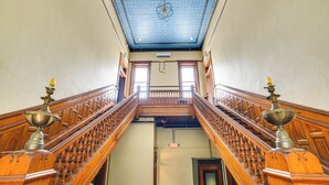 Una gran escalera con barandales ornamentados y un techo decorativo.