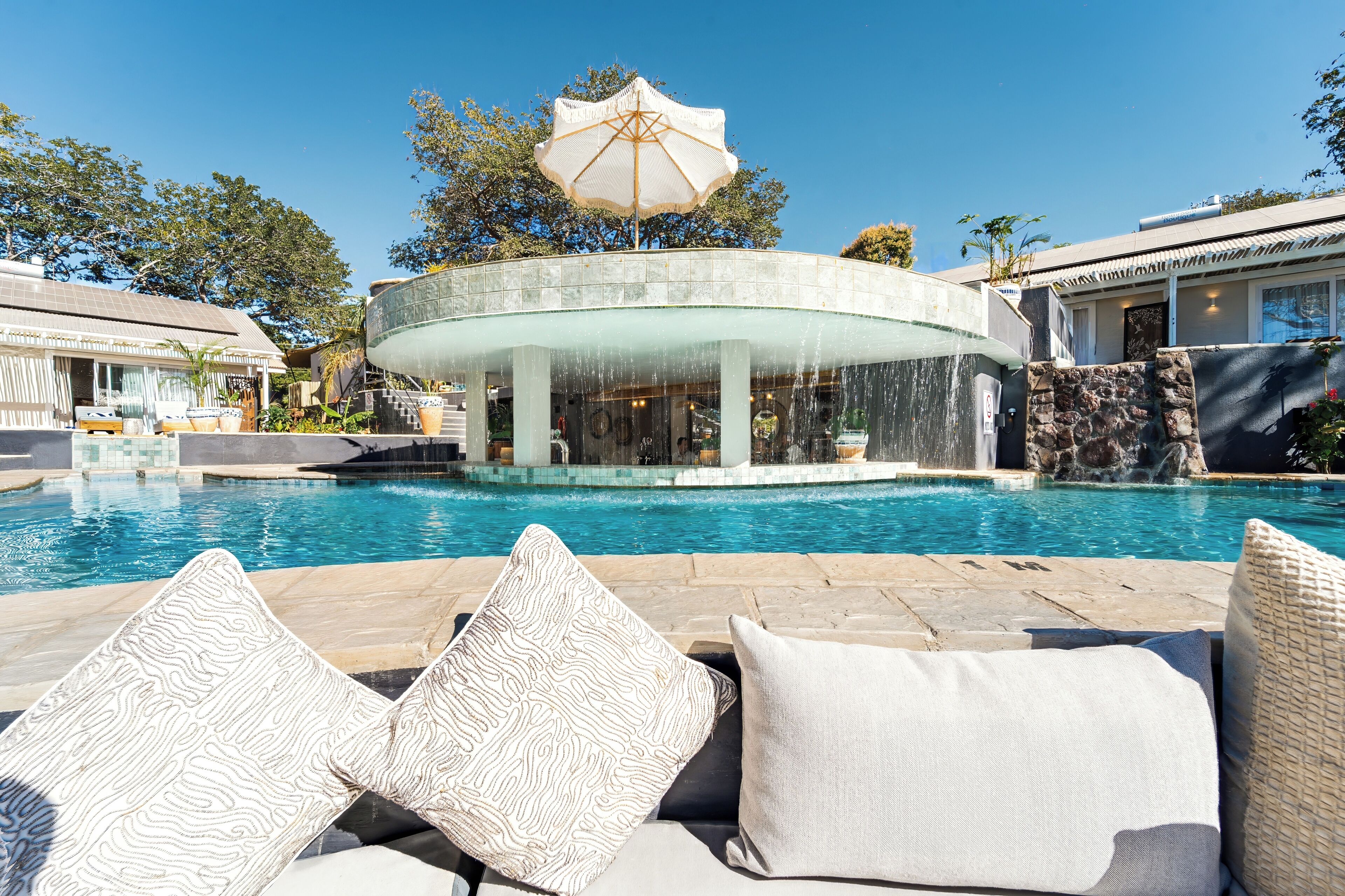 A pool area with lounge chairs and a water feature.