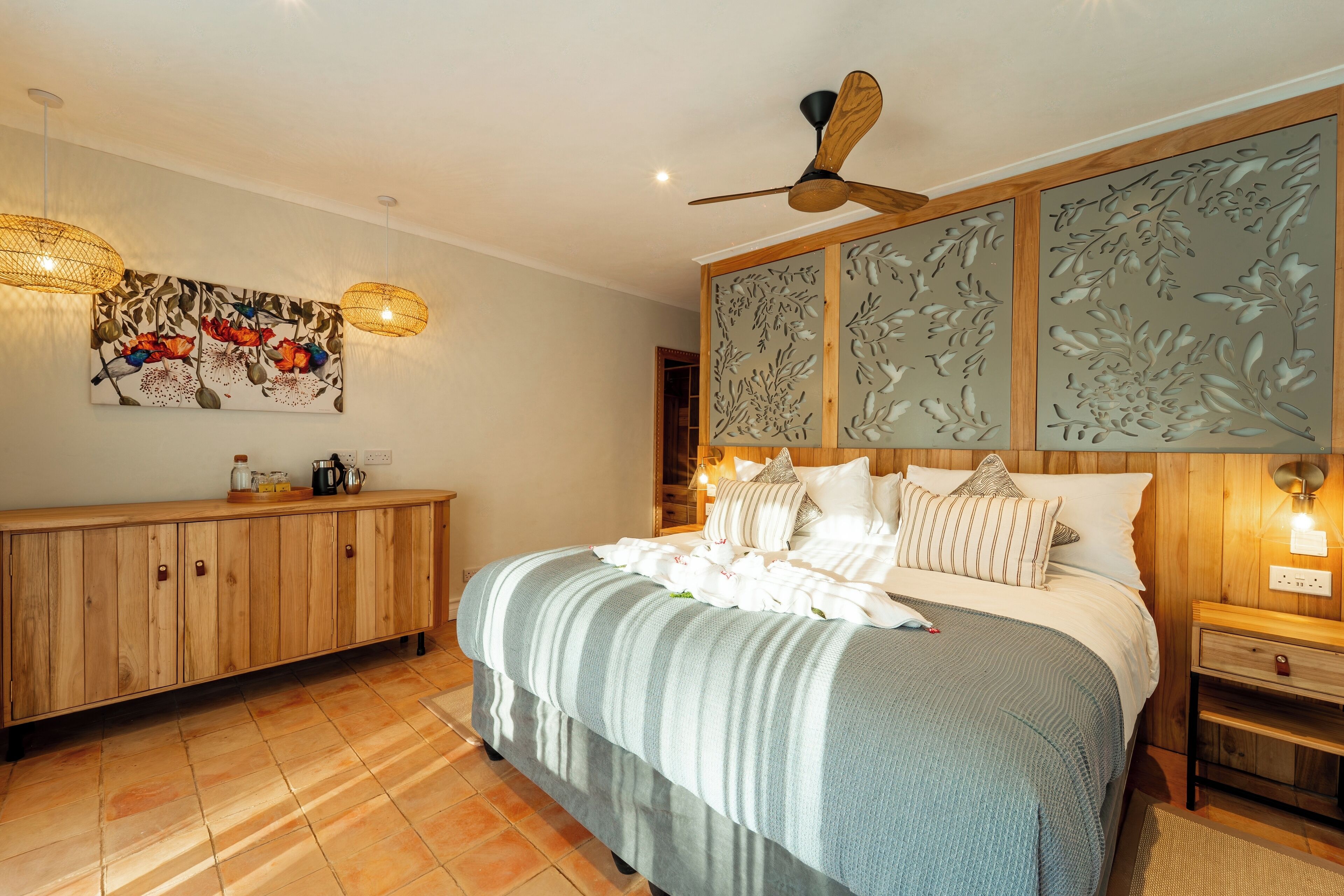 Un dormitorio con una cama grande, cabecera de madera y ventilador de techo.