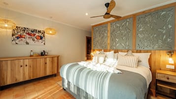 Un dormitorio con una cama grande, cabecera de madera y ventilador de techo.