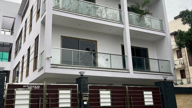 Un edificio residencial de varios pisos con balcones, entrada porticada y un diseño arquitectónico moderno.