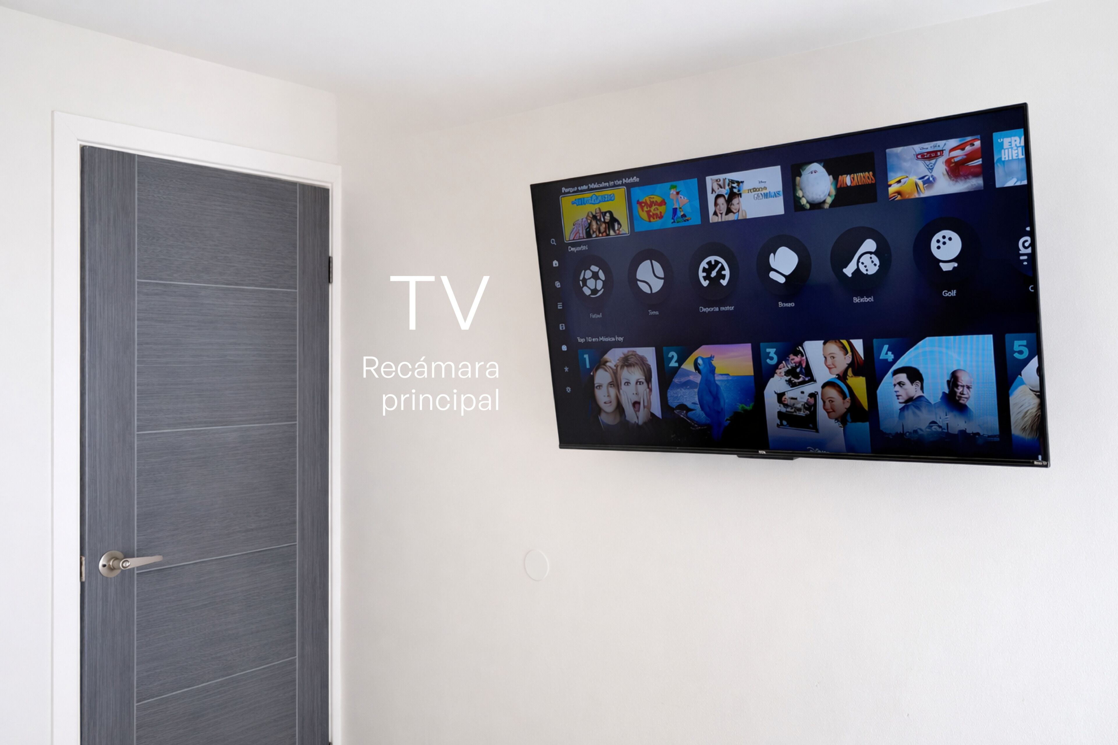 A TV mounted on a wall with a grid of icons and a door to the left.