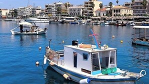 A marina with boats docked, calm water, and buildings in the background. - Grand Luxury Apartment Seafront Kalamata (Kalamata)
