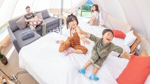 Una tienda de campaña con una cama, un sofá y una ventana.