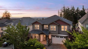 A suburban residential area with houses featuring gabled roofs and front yards with trees and shrubs. - Spectacular Hillside Escape w/ Valley Views, Game Room w/ Pool Table and Foosball, Huge Deck / Patio (Beaverton)