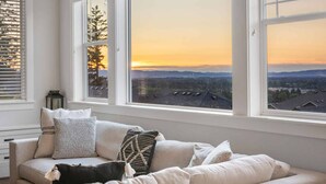 A room with a sofa, pillows, and a dog. - Spectacular Hillside Escape w/ Valley Views, Game Room w/ Pool Table and Foosball, Huge Deck / Patio (Beaverton)