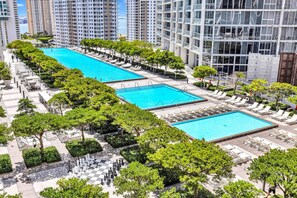 A rooftop swimming pool area with multiple pools, sun loungers, and a chessboard. - Icon Brickell - Pool & Ocean Views - Spa Access (Miami)
