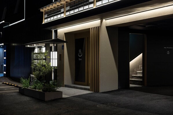 A modern building with a spa sign, a reception area, and a staircase leading to an upper level.