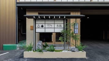 A restaurant entrance with a traditional Japanese aesthetic, including a shoji screen and signage indicating it serves ramen.