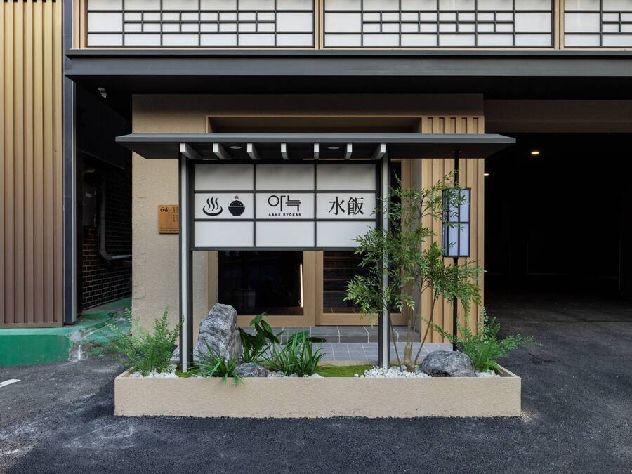 A restaurant entrance with a traditional Japanese aesthetic, including a shoji screen and signage indicating it serves ramen.