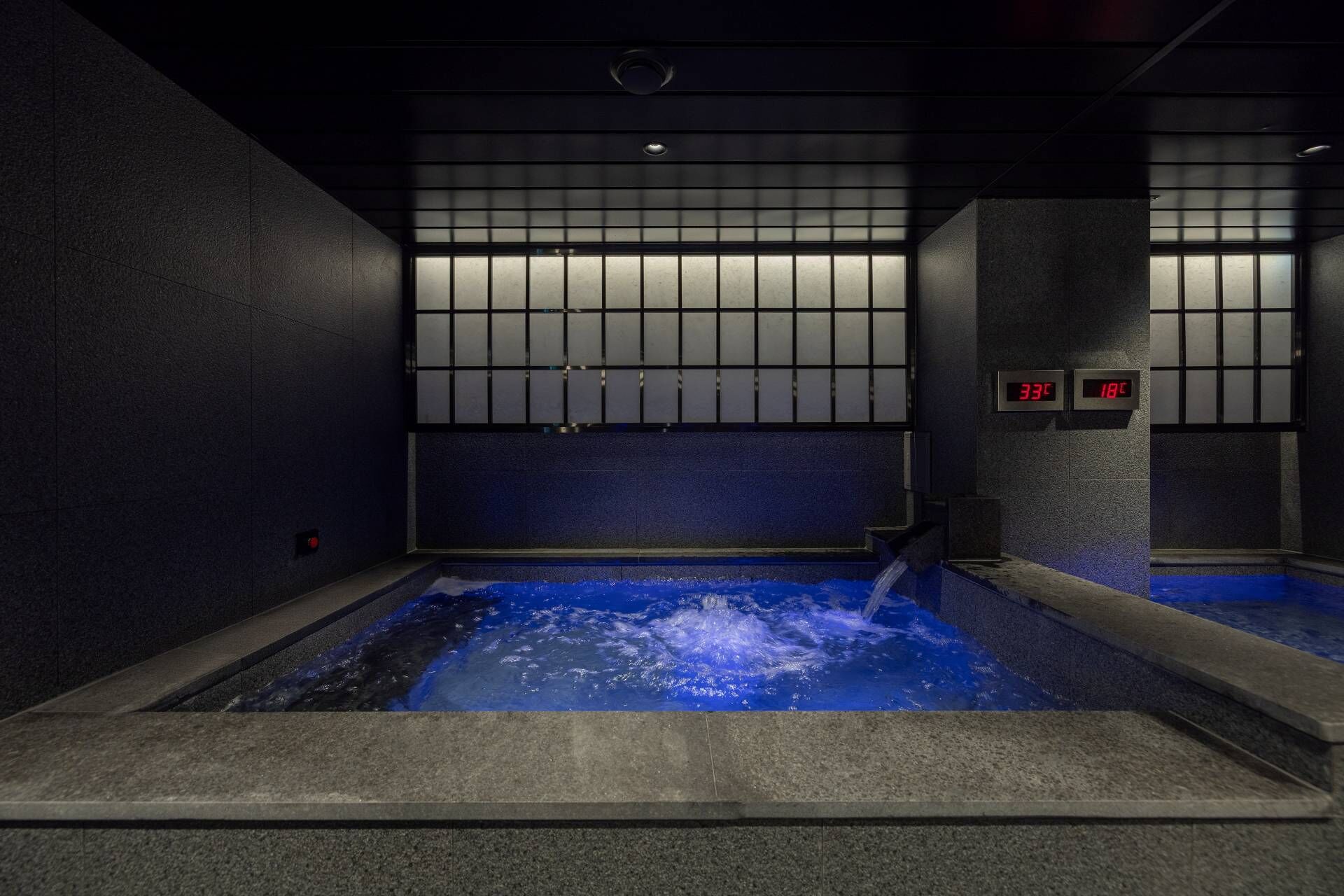Un spa moderne doté d’une piscine bleue chauffée, d’un thermomètre numérique et d’un design minimaliste.