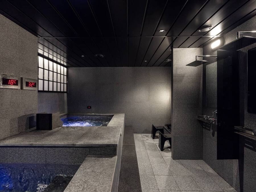 A modern spa with a hot tub, a sauna, and a massage area.