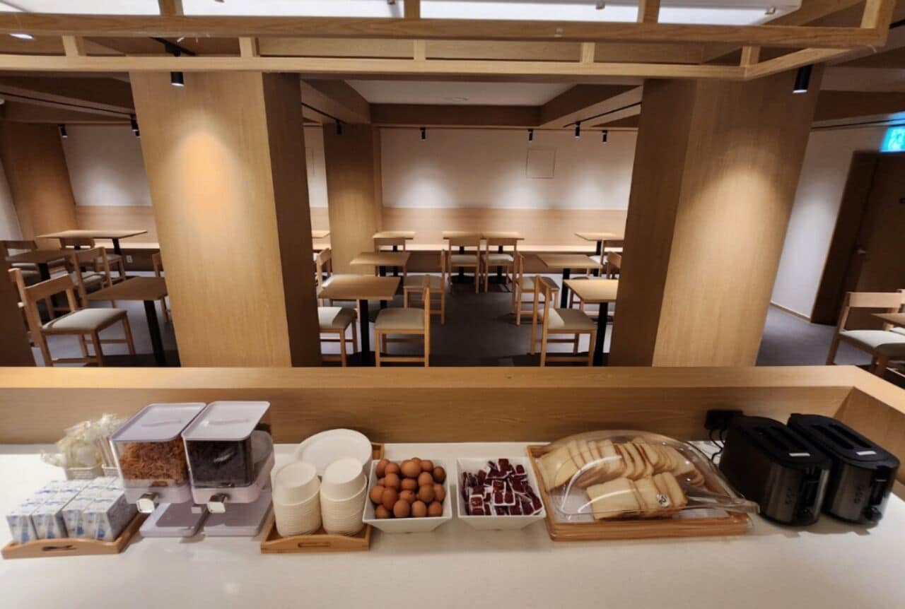 Um café com móveis de madeira e um balcão exibindo diversos alimentos.