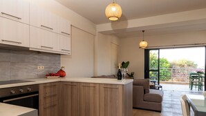 Una cocina moderna con una isla central, armarios de madera y una zona de comedor con sofá y mesa.