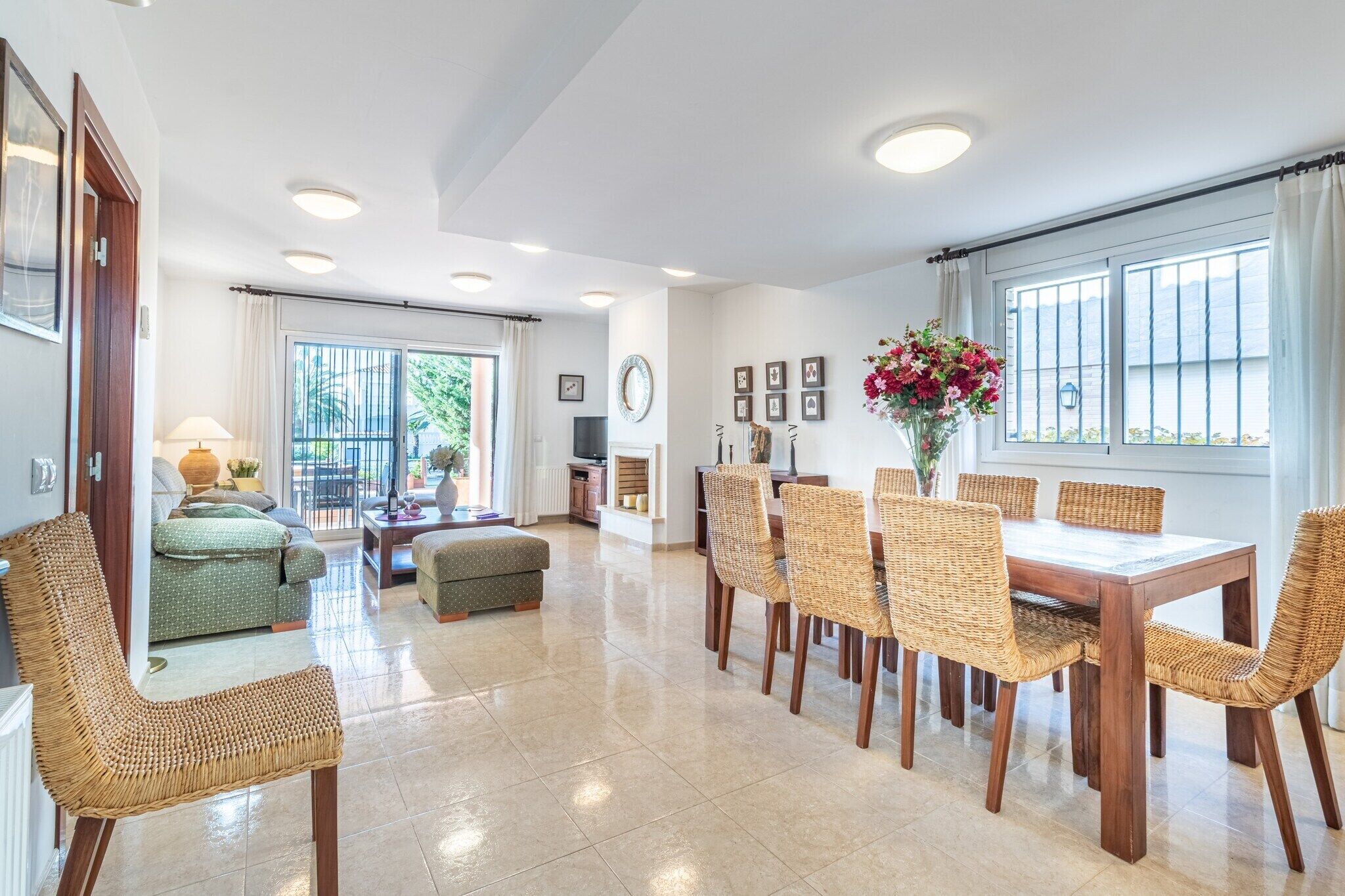 A spacious living room with a dining area, large windows, and a view of the outdoors.