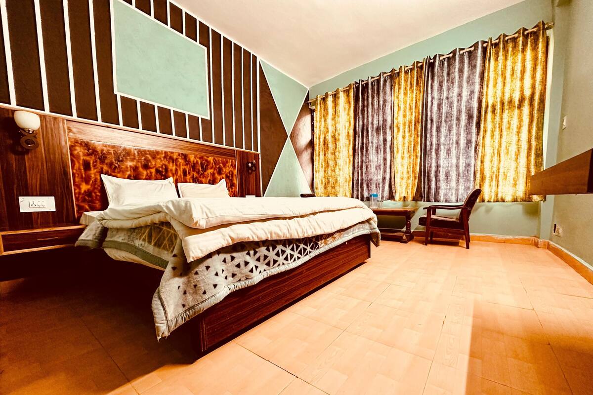 A bedroom with a bed, a desk, and a chair.