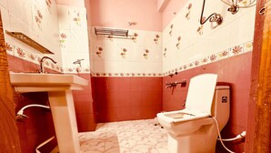 A bathroom with a toilet, sink, and shower.
