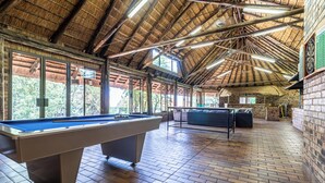 A pool table in a room with a high ceiling and brick walls. - Grand Manor  (Muldersdrift)
