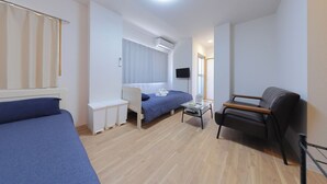 Habitación de hotel compacta con una cama individual, un escritorio, una silla y un televisor.