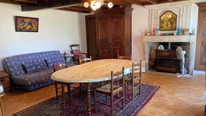 Una sala de estar con una mesa redonda, sofá y chimenea.