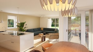 A modern kitchen with a central island, a dining area with a wooden table, and a living space with a sofa and a large window. - Private relaxation retreat for a family (TA Gasselte)