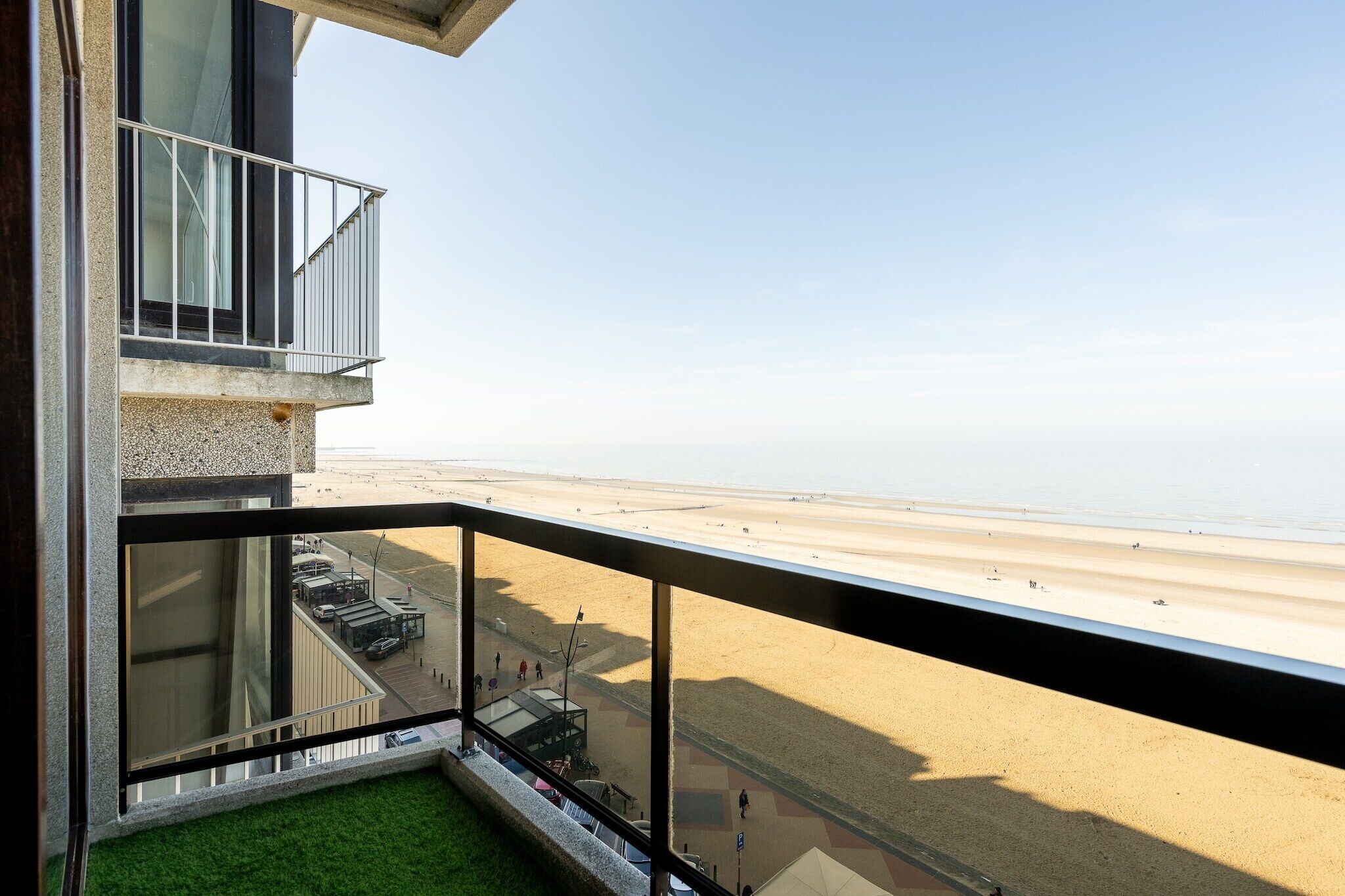 Un bâtiment moderne doté d’un balcon donnant sur une plage.