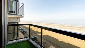 En moderne bygning med balkon der har udsigt over en strand.