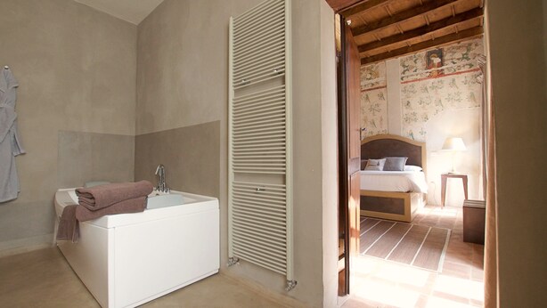 Un baño con bañera, toalla y radiador.