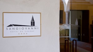 Un cartel para el Hotel Sangiovanni De Charmes con un logotipo sencillo y texto.
