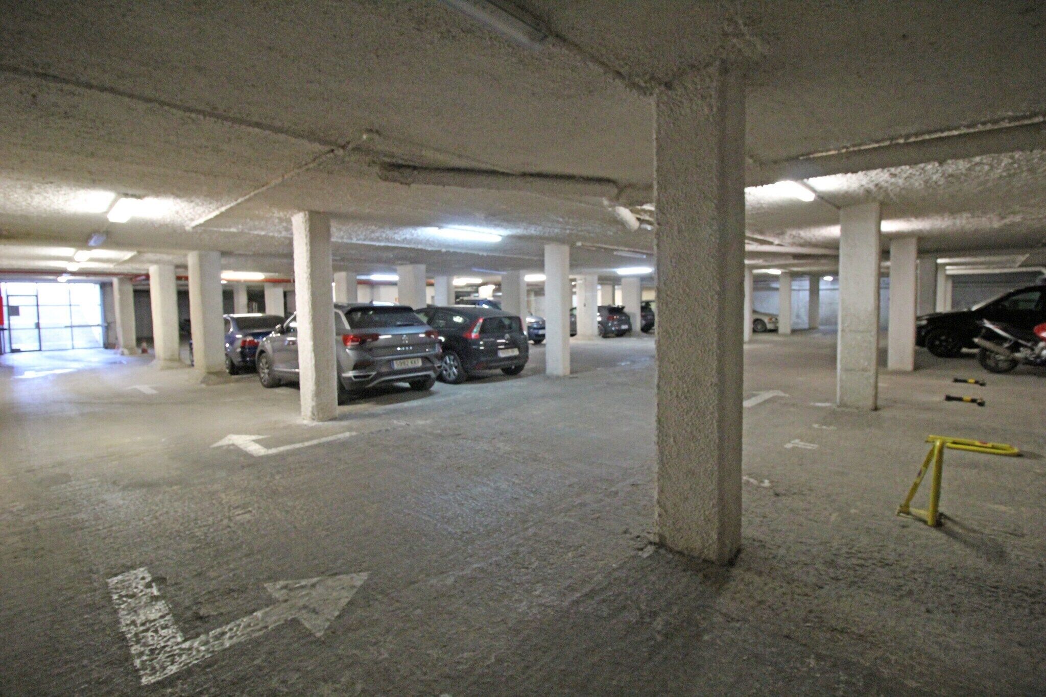 A multi-level parking garage with several cars parked.