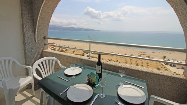 A balcony table with a view of the beach and ocean. - Studio in Empuriabrava with Ocean Views (Empuriabrava)