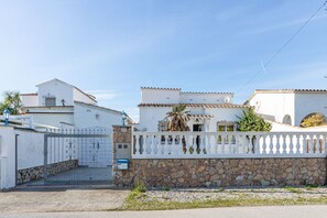A white building with a stone wall and a white fence. - Apartment in Empuriabrava near Sandy Beach (Empuriabrava)