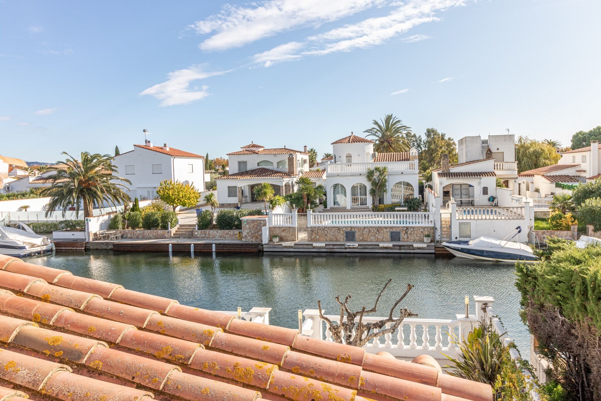 A marina with white buildings, boats, and a clear sky.