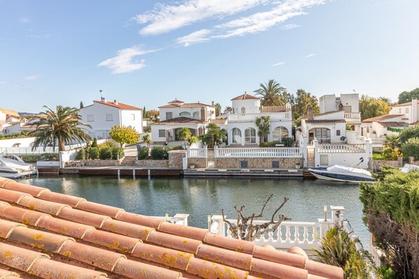 A marina with white buildings, boats, and a clear sky.