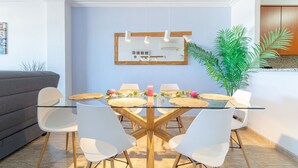 A dining area with a glass table, white chairs, and a wooden ceiling. - Apartment in Empuriabrava by the Beach (Empuriabrava)
