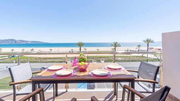 A table set for four with a view of the beach and ocean. - Apartment in Empuriabrava by the Beach (Empuriabrava)