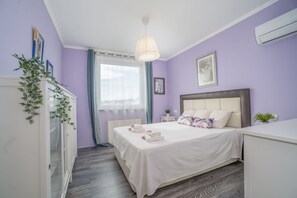 A bedroom with a bed, bedside table, and a hanging light fixture. - Villa in Empuriabrava with Private Pool (Empuriabrava)