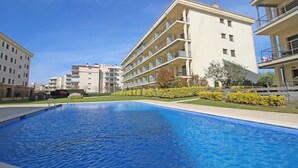 A swimming pool surrounded by modern apartment buildings with balconies. - Apartment in Roses near the Beach (Rosas / Roses)